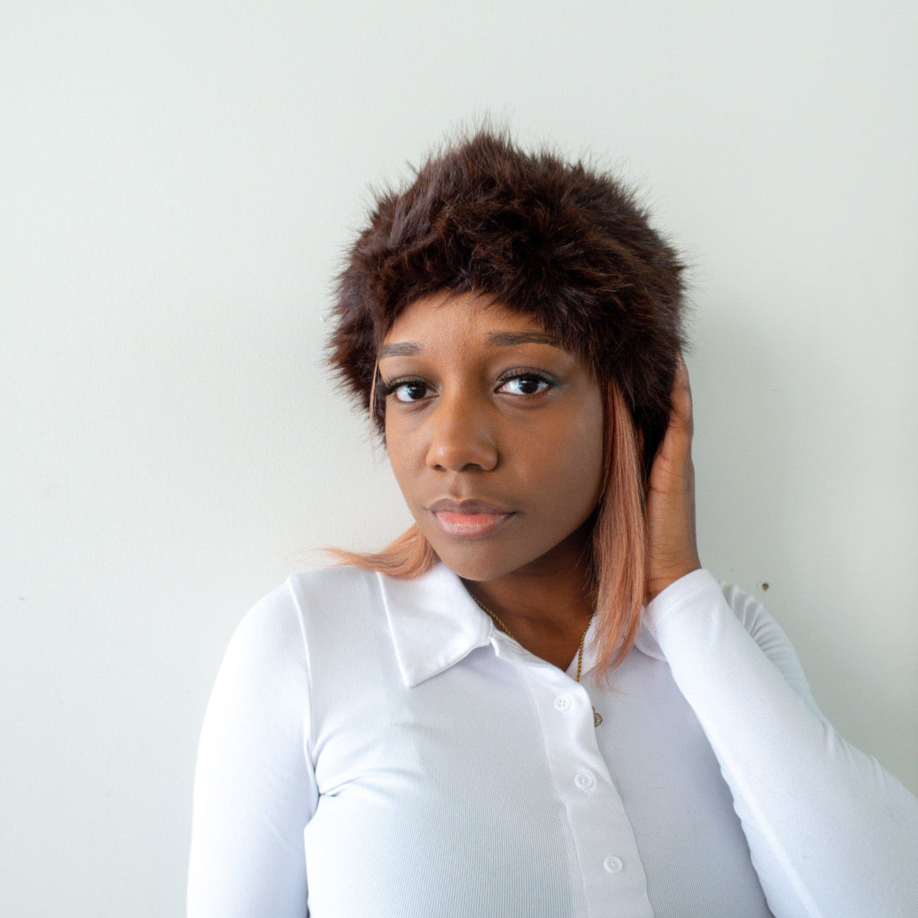 Person wearing a white shirt with long sleeves against a plain background